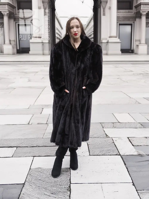 Black mink fur coat on model, long length with notched collar and buttonless front opening.