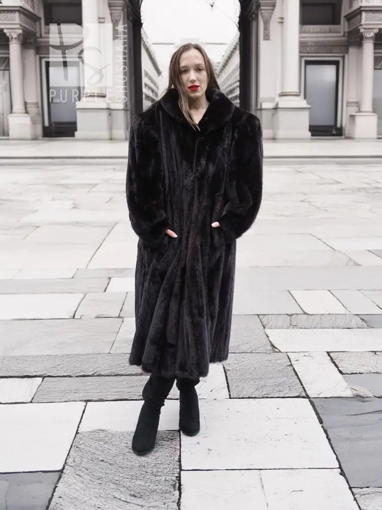 Black mink fur coat on model, long length with notched collar and buttonless front opening.