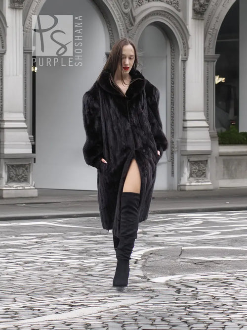 Black mink fur coat jacket with front wrap style and slit hem detail, full view.