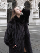 Black mink fur coat jacket with wide collar and dramatic long sleeves, side view.