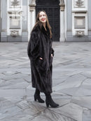 Black mink fur coat jacket with relaxed fit, long length, and wide collar, standing.