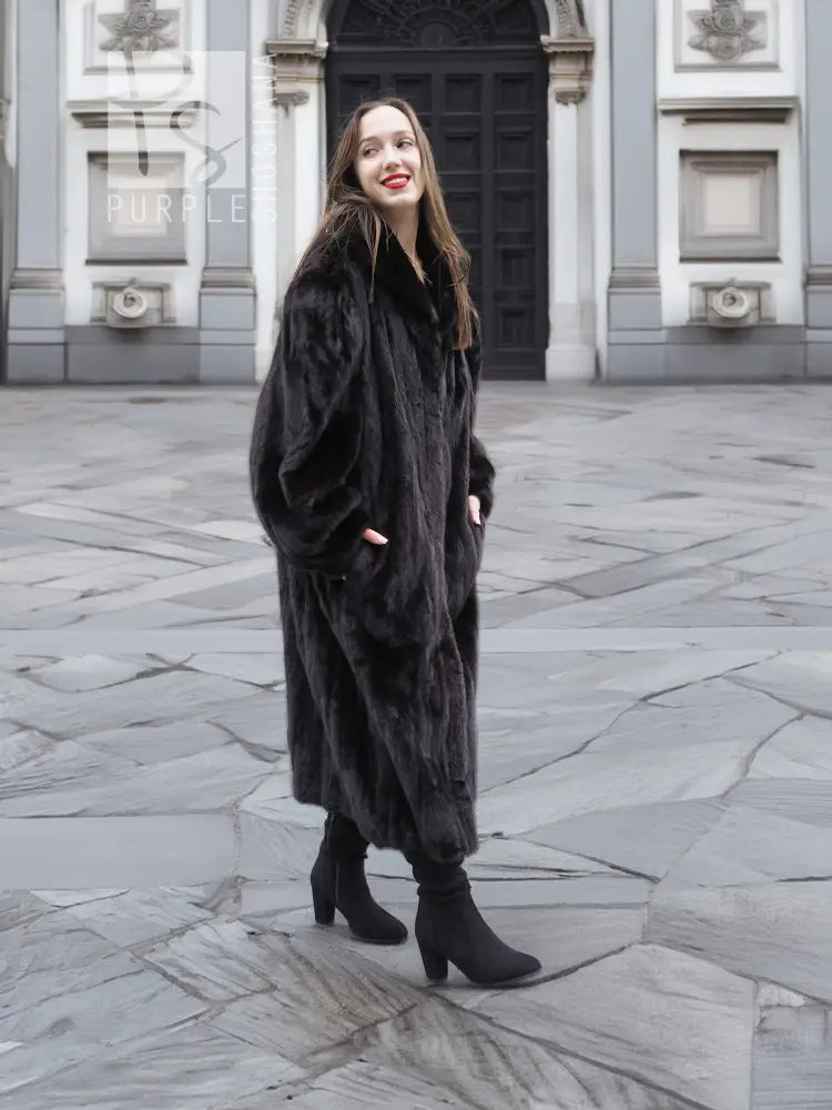 Black mink fur coat jacket with relaxed fit, long length, and wide collar, standing.