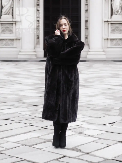Black mink fur coat featuring a long, structured flare with notched collar and long sleeves.