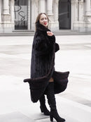 Black mink fur coat jacket with open front and long length, three-quarter side view.