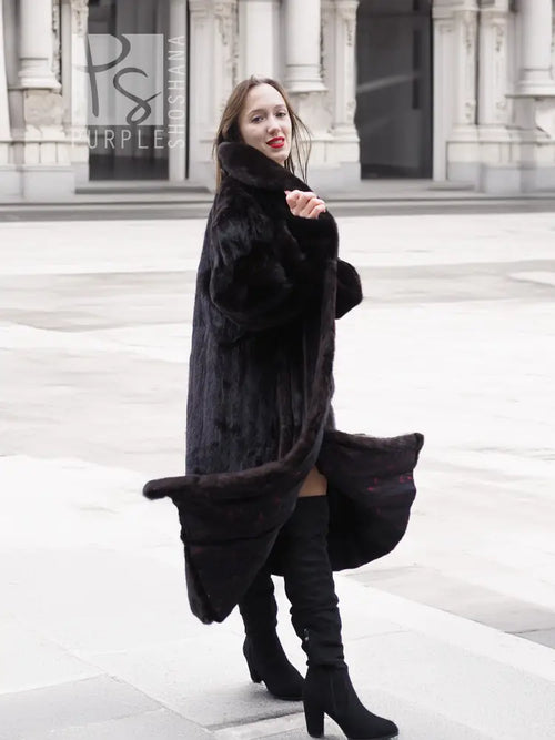 Black mink fur coat jacket with open front and long length, three-quarter side view.