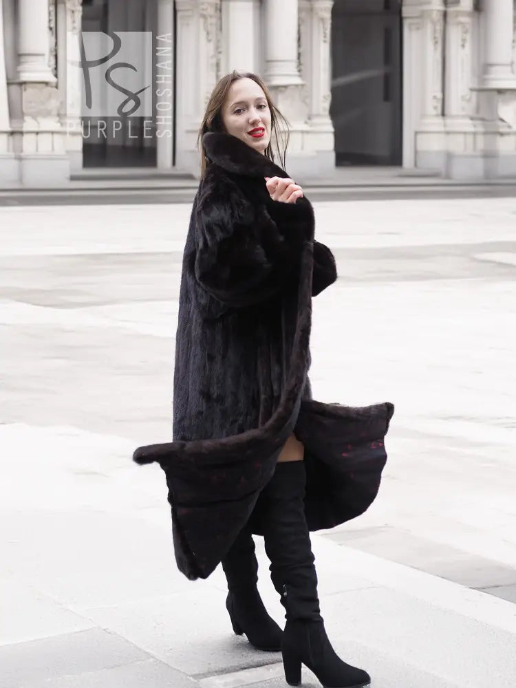 Black mink fur coat jacket with open front and long length, three-quarter side view.