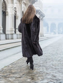 Black mink fur coat shown from back, long length with textured fur and wide sleeves.