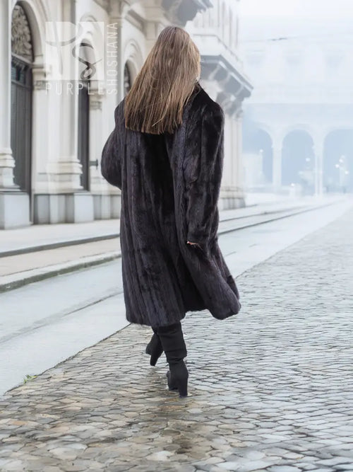 Black mink fur coat shown from back, long length with textured fur and wide sleeves.