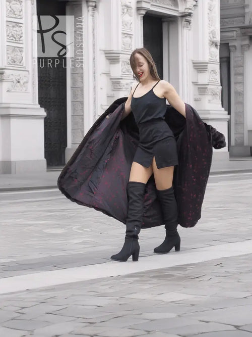 Black mink fur coat jacket with open front and broad fur sleeves, paired with boots.