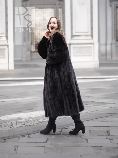 Black mink fur coat with long flared silhouette, notched collar, full sleeves, side pockets.