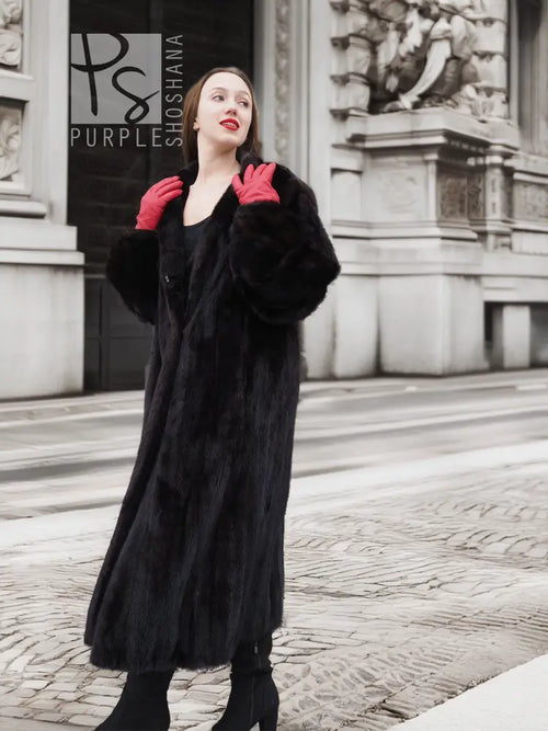 Black mink fur coat with full sleeves and large collar, red gloves