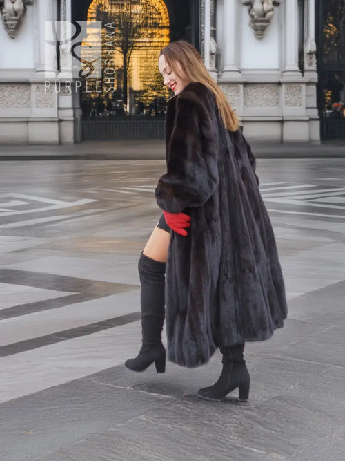 Black mink fur coat, side view, open front with voluminous fur sleeves and red gloves