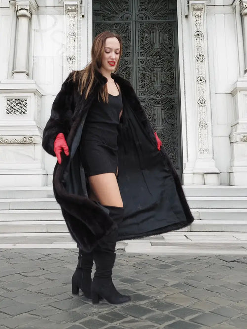 Black mink fur coat with swing shape, open front, voluminous sleeves, red gloves