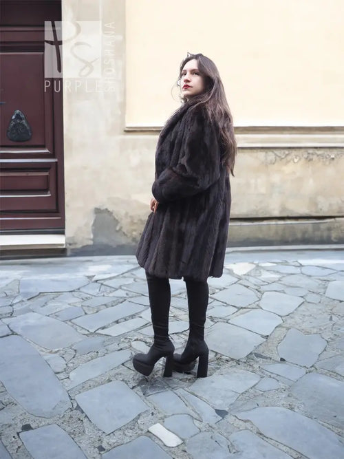 Dark mink fur jacket coat, hooded, side profile with long sleeves.
