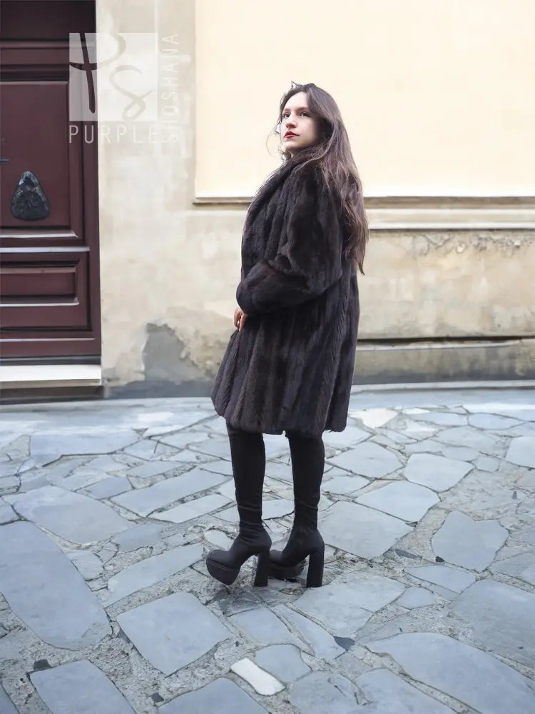 Dark mink fur jacket coat, hooded, side profile with long sleeves.