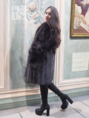 Black mink fur jacket with soft fur texture, long sleeves, side view indoors.