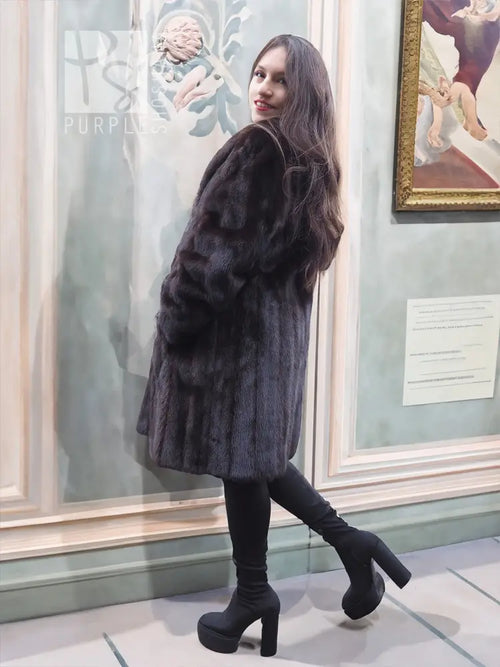 Black mink fur jacket with soft fur texture, long sleeves, side view indoors.