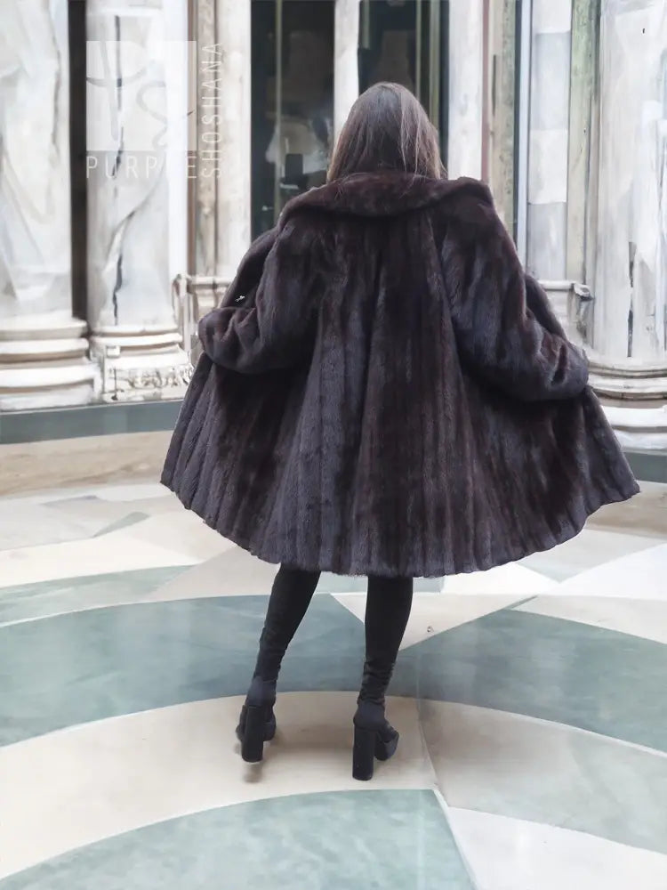 Dark hooded mink fur jacket coat, cape-like back, long sleeves.