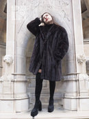 Black mink fur jacket with long sleeves, front closure, mid-thigh length.