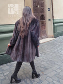 Black mink fur jacket with long sleeves and flared back, viewed from behind.
