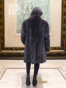 Dark mink fur jacket coat, hooded with long sleeves, back view.