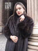 Dark mink fur jacket coat with hood, front view, hand at collar.