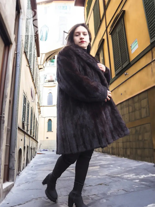 Black mink fur jacket with plush texture, long sleeves, side view.