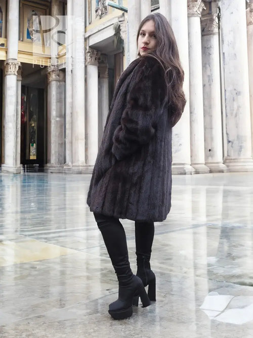 Black mink fur jacket with long sleeves, textured fur, side profile.