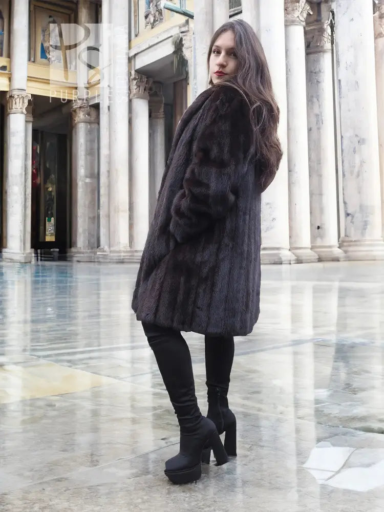 Black mink fur jacket with long sleeves, textured fur, side profile.