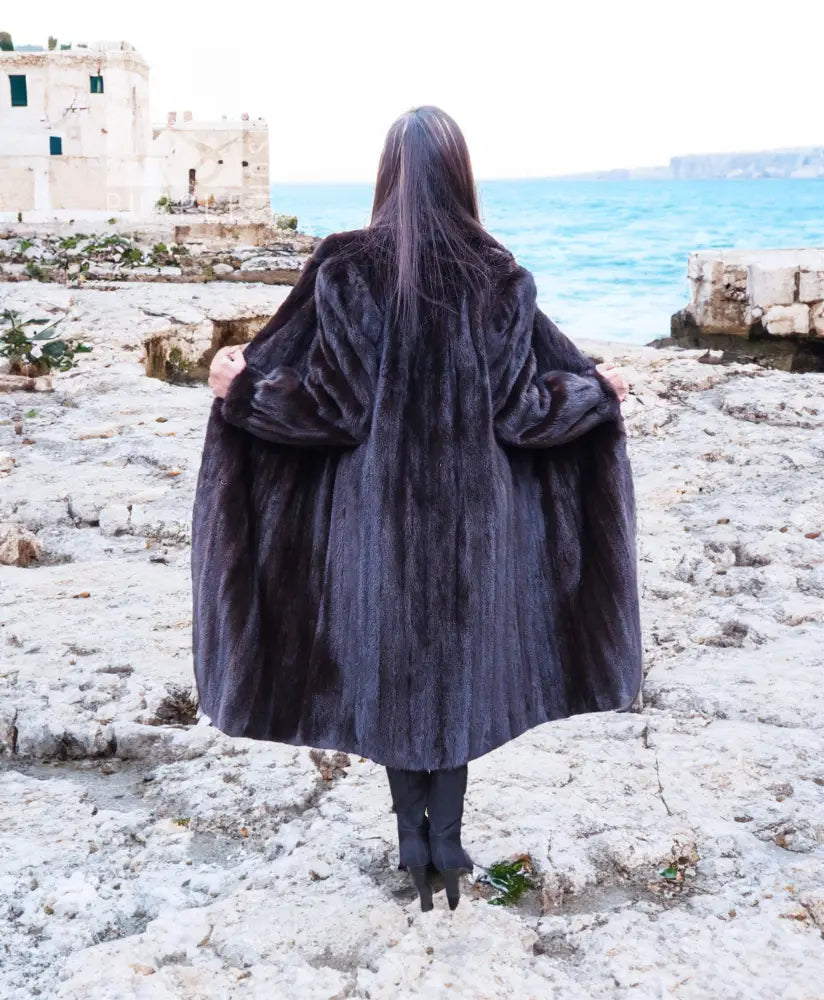 Long dark mink fur jacket with notched collar and straight, full-length silhouette