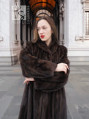Dark brown mink fur coat with raised collar and clasped hands, close view