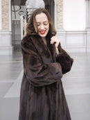 Dark brown mink fur coat with wide ruffle collar and side details, arms crossed