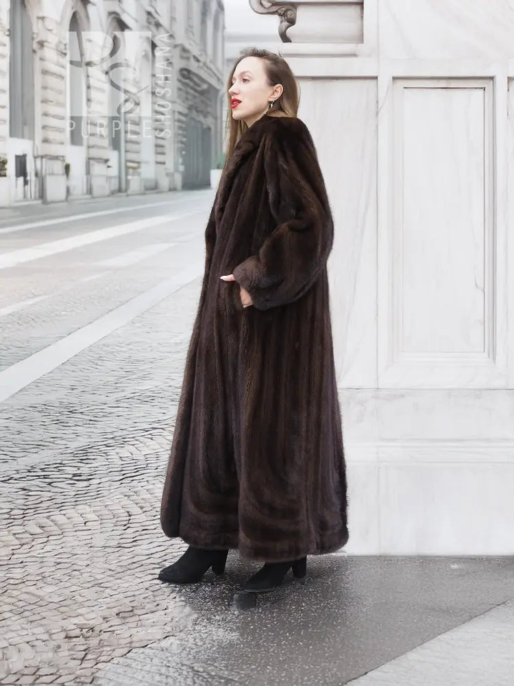 Long dark brown mink fur coat with hooded neckline, three-quarter side view