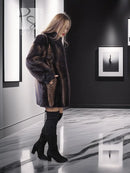 Women's two-tone mink jacket viewed from back, dark fur with tan herringbone center.