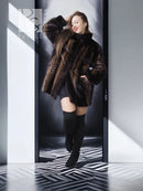 Women's two-tone mink jacket with wide sleeves and tan herringbone center panel on dark fur.