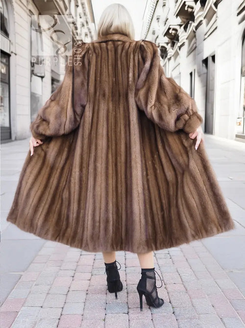 Back view of dark brown mink fur coat showing seams and voluminous sleeves