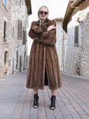 Dark brown mink fur coat with thick collar and buttonless front, arms crossed