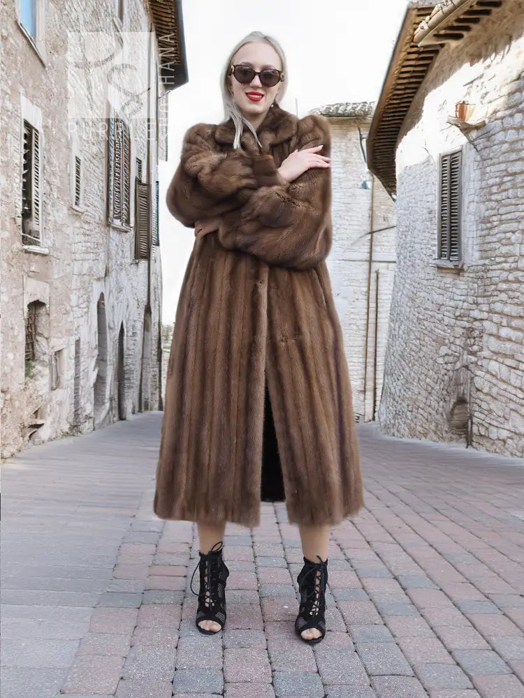 Dark brown mink fur coat with thick collar and buttonless front, arms crossed