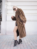 Dark brown mink fur coat with hood and wide sleeves, front view with crossed arms
