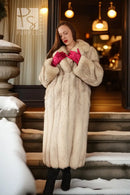 Cream plush fox fur full-length coat with notch collar, front view with folded hands