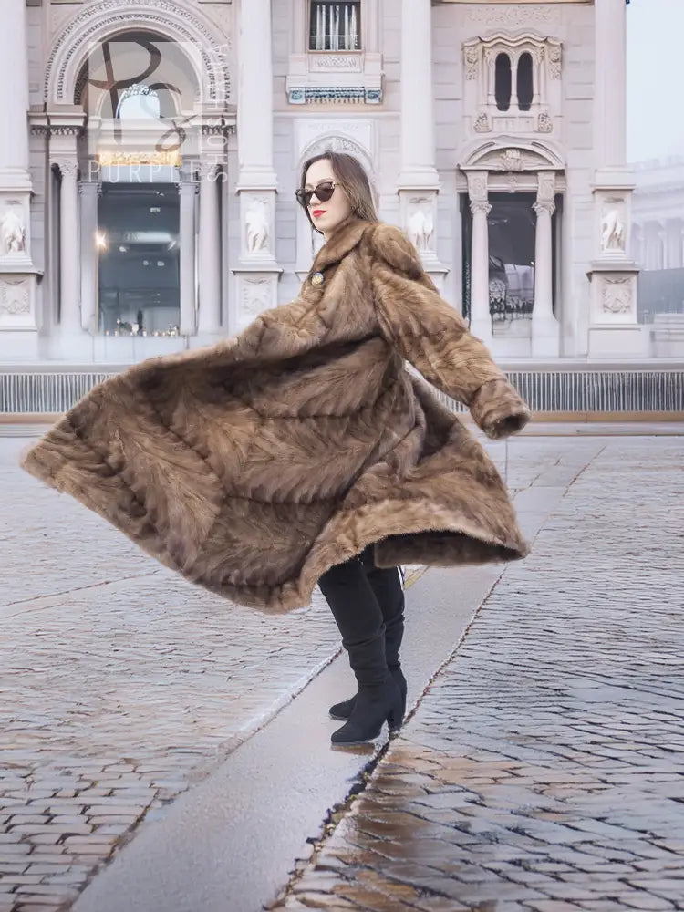 Long mink fur coat with swing shape and button front, shown from the side in espresso brown.