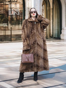 Long mink fur section coat in espresso brown with buttoned front and shawl collar.