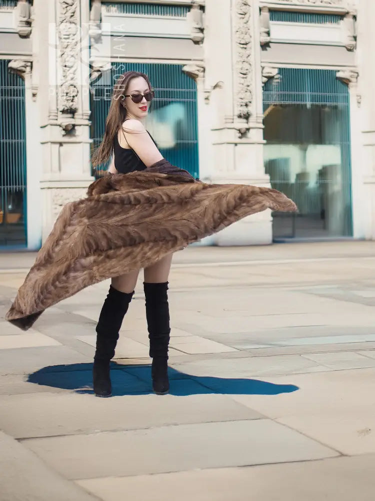 Long mink coat with wide swing hem and textured fur, draped to the side