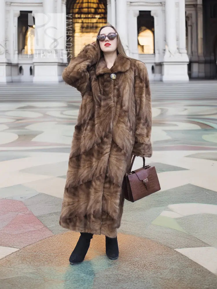 Long mink fur section coat in espresso brown with button closure and roomy swing silhouette.