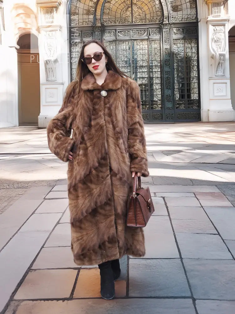Long mink fur section coat in espresso brown with button front and wide shawl collar.