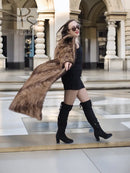 Long mink section coat in brown with wide collar and button front; side pose
