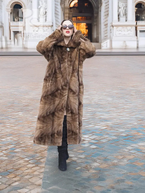 Long mink fur section coat in espresso brown with button front and wide swing shape.