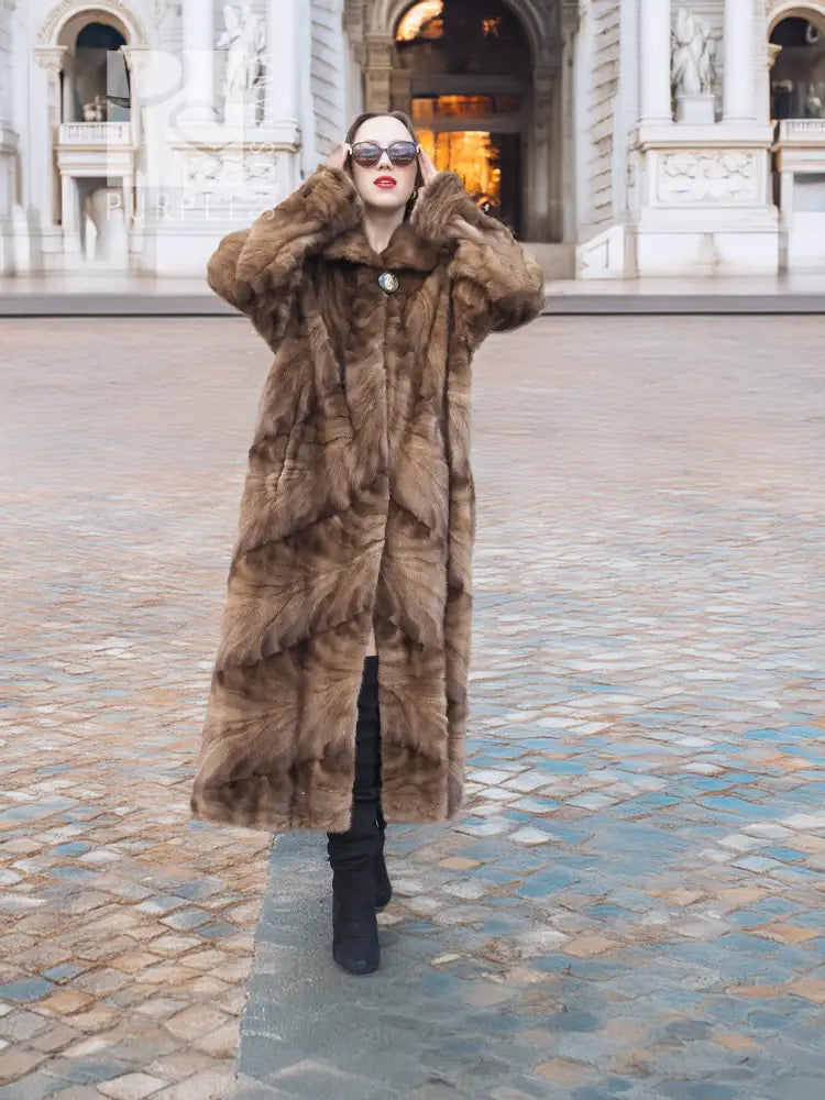 Long mink fur section coat in espresso brown with button front and wide swing shape.