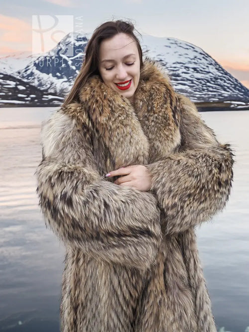 Tan raccoon fur coat with shawl collar, close-up of open front and arms crossed.