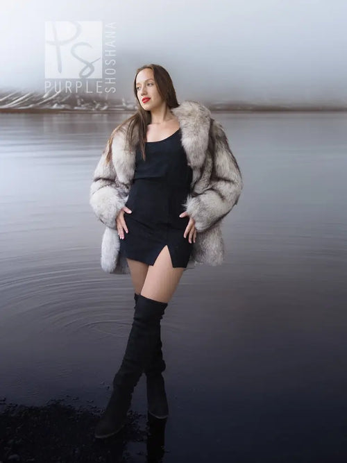 Gray fur coat with sculptural collar, open front over black dress and tall boots